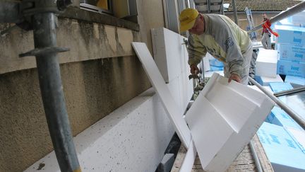 Mise en place par des ouvriers, à Auch, d'un système d'isolation thermique, avec des plaques d'isolant en polystyrène.&nbsp; (SEBASTIEN LAPEYRERE / MAXPPP)