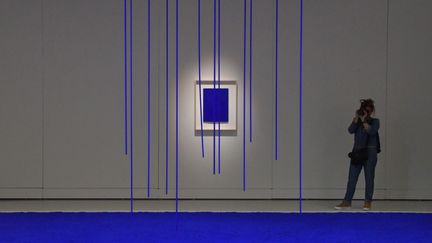 Une femme prend une photo lors de l'exposition "Yves Klein, des cris bleus" au musée Soulages de Rodez le 20 juin 2019. (PASCAL PAVANI / AFP)