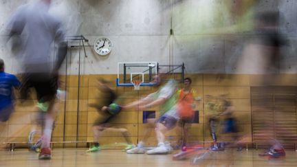 Des joueurs amateurs de handball dans un gymnase. Photo d'illustration. (JOHN MACDOUGALL / AFP)