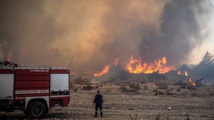 Un pompier grec, lors des incendies de l'île de Rhodes, le 25 juillet 2023. (ANGELOS TZORTZINIS / AFP)