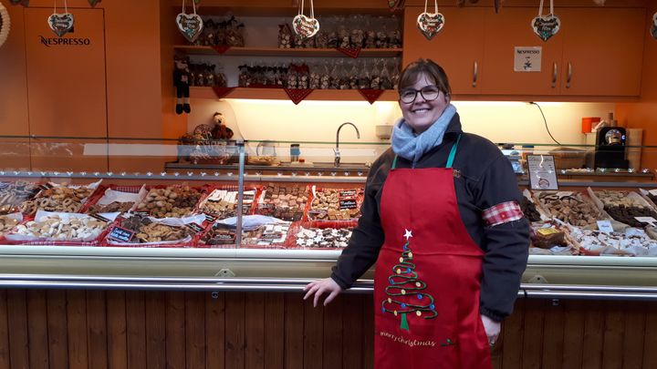 Après l'attentat du 11 décembre, Laurence, vendeuse de Bredele sur le marché de Broglie, brassard en hommage aux victimes. (BENJAMIN ILLY / FRANCE-INFO)