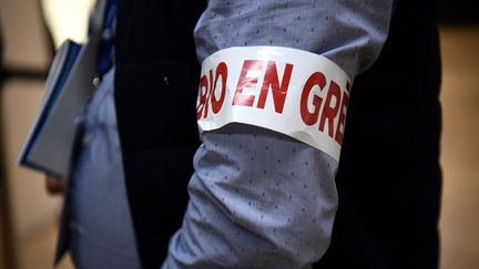 Un biologiste médical porte un brassard "bio en grève" lors d'une manifestaion à Paris, le 1er décembre 2022. (AFP)