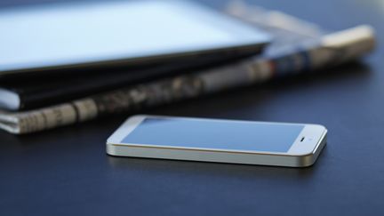 Newspapers and a smartphone.  (KLAUS VEDFELT / DIGITAL VISION VIA GETTY IMAGES)