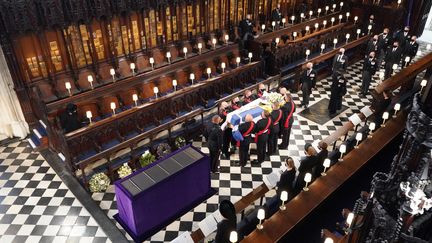 A la fin de la cérémonie, le cercueil du prince Philip a été&nbsp;descendu caveau royal.&nbsp;La dépouille du duc d'Edimbourg y restera jusqu'à ce que la reine l'y rejoigne à sa mort. Les époux ainsi réunis auront alors pour dernière demeure la chapelle du Memorial du roi George VI, père d'Elizabeth II. (DOMINIC LIPINSKI / POOL / AFP)