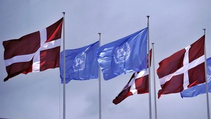 Drapeaux danois et ceux de l'ONU flottent au-dessus du Bella Center de Copenhague où a lieu la conférence (AFP PHOTO / ATTILA KISBENEDEK)