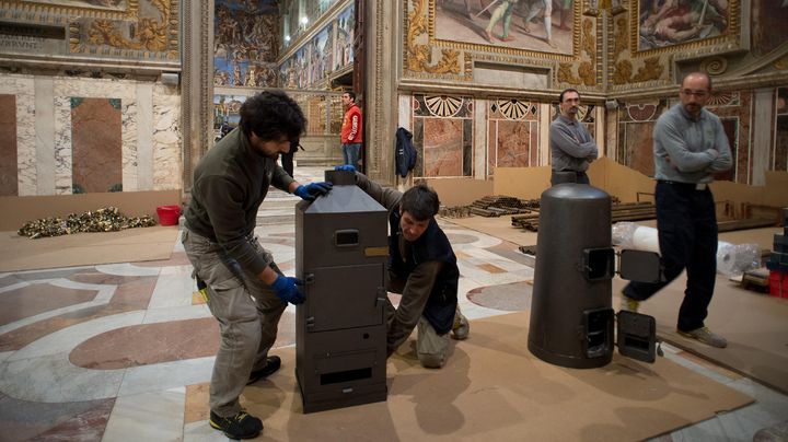 Des ouvriers installent les deux po&ecirc;les dans la chapelle Sixtine, au Vatican, le 7 mars 2013. (OSSERVATORE ROMANO / REUTERS)