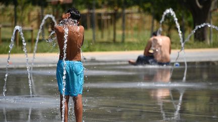 Un enfant se rafarichit à Montpellier, le 27 juin 2019. (PASCAL GUYOT / AFP)