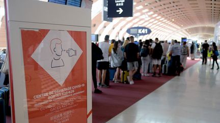 Un panneau indique la direction d'un centre de dépistage du Covid-19 dans un terminal de l'aéroport Roissy-Charles de Gaulle, le 20 juillet 2021. (ERIC PIERMONT / AFP)