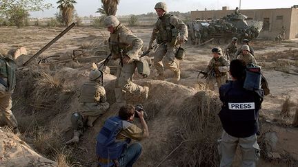 «shootent» des marines américains se réfugiant dans une tranchée, suite à une attaque d’Irakiens près du palais présidentiel à Bagdad le 11 avril 2003.Deux jours après la chute de Bagdad, les forces américaines étaient confrontées à des poches de résistance. Autre part en Irak : voir le reportage de The battle of Dyala bridge* (mars/avril 2003) du photographe Gary Knight. (AFP PHOTO/ERIC FEFERBERG)