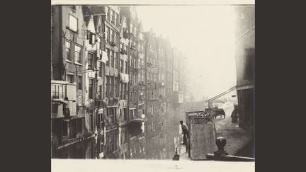 Ce vieux quartier où la façade arrière des maisons tombe directement dans le canal était déjà un des lieux très visités d&#039;Amsterdam. Breitner n&#039;a pas photographié les bâtiments modernes ni le tramway électrique, qu&#039;il n&#039;aimait pas
 (Collection Rijksmuseum Amsterdam)