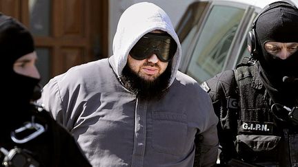 Le groupe d'intervention de la police nationale (GIPN) emm&egrave;ne Mohamed Achamlane, arr&ecirc;t&eacute; le 30 mars 2012 &agrave; son domicile de Bouguenais, pr&egrave;s de Nantes (Loire-Atlantique).&nbsp; (JEAN-SEBASTIEN EVRARD / AFP)