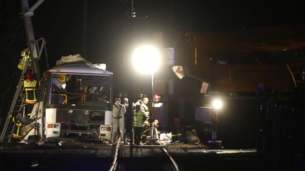 Des pompiers et des policiers sur les lieux de l'accident entre un car scolaire et un TER, à Millas, près de Perpignan (Pyrénées-Orientales), jeudi 14 décembre 2017.&nbsp; (RAYMOND ROIG / AFP)