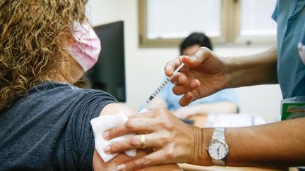 Une soignante reçoit le vaccin&nbsp;développé par l'américain&nbsp;Pfizer&nbsp;et l'allemand&nbsp;BioNTech à Petah Tikva (Israël), le 20 décembre 2020 (illustration). (NIR KEIDAR / ANADOLU AGENCY / AFP)