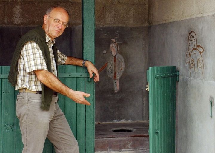 Le maire de Sainte-Florence montre les latrines de l'ancienne école communale décorées par des oeuvres de Gaston Chaissac et classé monument historique en 1998.
 (FRANK PERRY / AFP)