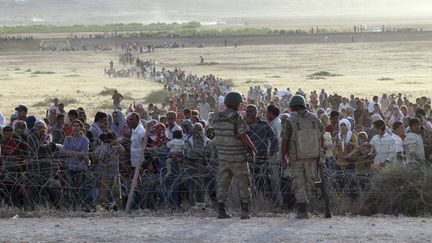  (Des milliers de Kurdes syriens arrivent à la frontière syrio-turque, située à une dizaine de kilomètres de la ville de Konabi où les djihadistes du groupe Etat islamique (EI) sèment la terreur © REUTERS/Kadir Celikcan)