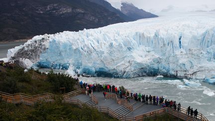 Des touristes rassemblés pour assister à la rupture du glacier Perito Moreno,&nbsp;en Patagonie (Argentine), le 10 mars 2018. (WALTER DIAZ / AFP)