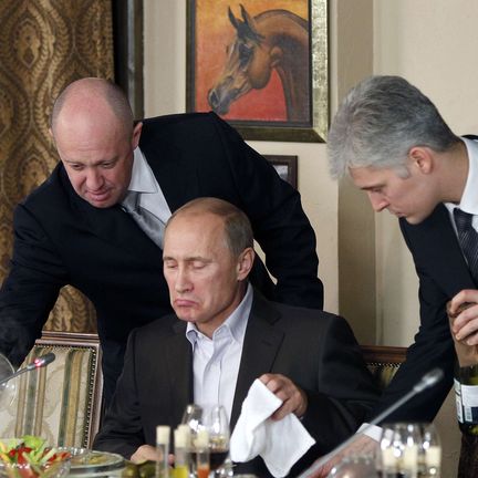 Evguéni Prigojine (à gauche) présente un plat à Vladimir Poutine, alors Premier ministre de Russie, dans l'un de ses restaurants près de Moscou (Russie), le 11 novembre 2011. (MISHA JAPARIDZE / AP / SIPA)