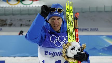 Quentin Fillon Maillet célèbre sa victoire sur le podium après l'individuel en biathlon, mardi, aux JO de Pékin. (ODD ANDERSEN / AFP)