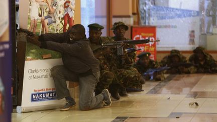 Des soldats et un policier&nbsp;k&eacute;nyan arm&eacute; &agrave; la recherche des hommes arm&eacute;s et masqu&eacute;s qui ont ouvert le feu le 21 septembre 2013 sur les clients et le personnel d'un centre commercial de luxe &agrave; Nairobi (Kenya). (GORAN TOMASEVIC / REUTERS)