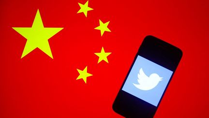 Le logo de Twitter représenté dans l'écran d'un smartphone avec le drapeau chinois en arrière-plan (illustration). (BEATA ZAWRZEL / NURPHOTO)