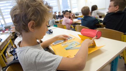 Un &eacute;l&egrave;ve sort ses affaires d'&eacute;cole le jour de la rentr&eacute;e, le 3 septembre 2009.&nbsp; (SERGE POUZET / SIPA)