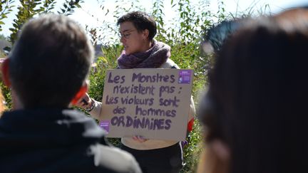 Une organisatrice, Elise, prononce un discours lors du rassemblement de soutien à Gisèle Pelicot à Auxerre (Yonne), le 14 septembre 2024, avec une pancarte soulignant que "les violeurs sont des hommes ordinaires". (YANN THOMPSON / FRANCEINFO)