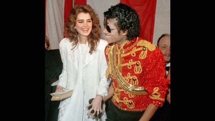 Michael Jackson porte son fameux gant à cristaux noirs, en compagnie de l'actrice Brook Shields, le 16 janvier 1984 aux American Music Awards.
 (DOUG PIZAC/AP/SIPA)