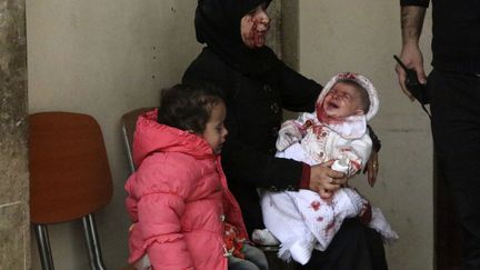 Une femme et son b&eacute;b&eacute; patientent aux urgences de l'h&ocirc;pital d'Alep (Syrie), apr&egrave;s avoir surv&eacute;cu &agrave; un bombardement attribu&eacute; aux forces du pr&eacute;sident Bachar Al-Assad, le 9 mars 2014. (REUTERS)