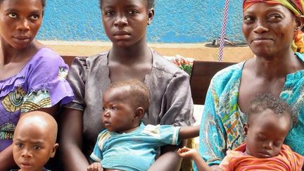 Le 13 mars 2018, en RDC, des mères attendent avec leurs enfants sur les genoux des rations sur un site de distribution du Programme alimentaire mondial, dans la région instable du Kasaï. (Kate Bartlett / DPA)