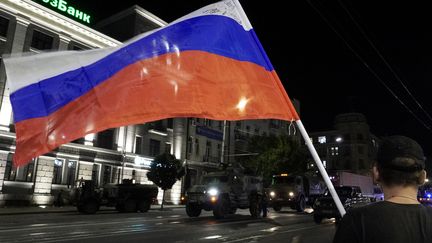 Un homme brandit le drapeau national russe alors que les membres du groupe Wagner retournent à leur base de Rostov, le 24 juin 2023. (STRINGER / AFP)