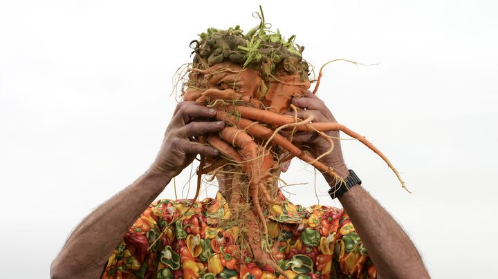 Ian Neale brandit fi&egrave;rement sa botte de carottes qui a remport&eacute; le 1er prix durant le "Autumn flower show" &agrave; Harrogate (Royaume-Uni), le 13 septembre 2013. (NIGEL RODDIS / REUTERS)