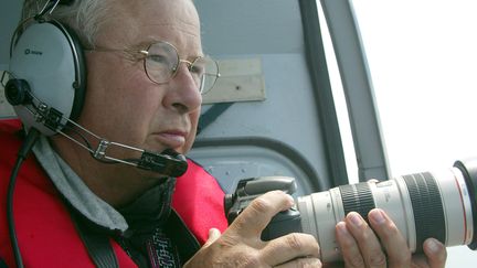 Le photographe de la mer Philip Plisson survole en h&eacute;licopt&egrave;re le port de la Trinit&eacute;-sur-Mer (Morbihan),&nbsp;le 17 juin 2003. (MARCEL MOCHET / AFP)