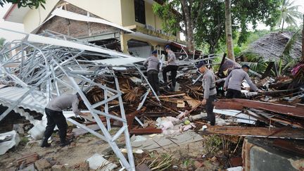 Des policiers indonésiens recherchent des survivants&nbsp;après le passage d'un tsunami,&nbsp;à Carita (Indonésie), le 24 décembre 2018. (SONNY TUMBELAKA / AFP)