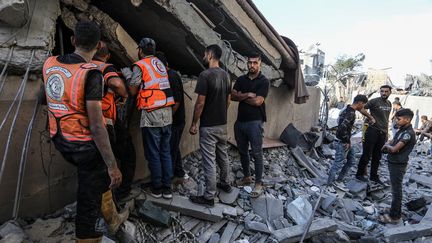 Rescue teams and residents carry out a rescue operation in the Menara district of Khan Younes, Gaza Strip, October 2, 2024. (ABED RAHIM KHATIB / ANADOLU / VIA AFP)