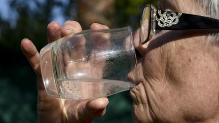 Une femme boit un verre d'eau à Hyères (Var), le 10 juillet 2023. (MAGALI COHEN / HANS LUCAS / AFP)