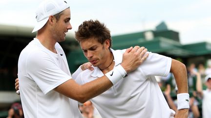 John Isner (gauche) réconforte le Français Nicolas Mahut (droite), le 24 juin 2010 à Wimbedon. L'Américain s'est imposé&nbsp;6/4, 3/6, 6/7, 7/6, 70/68 après 11 heures et 5 minutes de jeu sur trois jours ! (ALISTAIR GRANT / POOL / AP POOL)