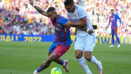 Le Barcelonais Memphis Depay (à gauche) à la lutte avec le Madrilène Casemiro, lors du Clasico du 24 octobre 2021, au Camp Nou. (LLUIS GENE / AFP)