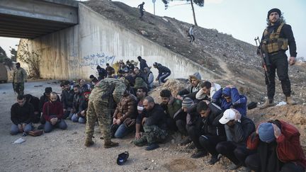 Des soldats du gouvernement et de ses alliés sont arrêtés par des rebelles opposés au régime de Bachar al-Assad, sur la route entre Homs et Damas, le 8 décembre 2024. (GHAITH ALSAYED / AP / SIPA)