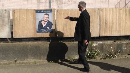 Le candidat à la présidentielle Jean Lassalle, devant une affiche de sa campagne, dans son fief de Lourdios-Ichères (Pyrénées-Atlantiques), le 10 avril 2022. (GAIZKA IROZ / AFP)