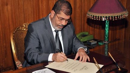 Le pr&eacute;sident &eacute;gyptien, Mohamed Morsi, a sign&eacute; le d&eacute;cret d'application de la nouvelle Constitution adopt&eacute;e par r&eacute;f&eacute;rendum, le 26 d&eacute;cembre 2012 au palais pr&eacute;sidentiel du Caire (Egypte).&nbsp; (EGYPTIAN PRESIDENCY / AFP)