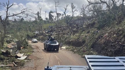 Des militaires de la gendarmerie nationale tentent d'emprunter un axe routier bloqué par les arbres à Mayotte, le 15 décembre 2024, après le passage du cyclone Chido. (SIPA)