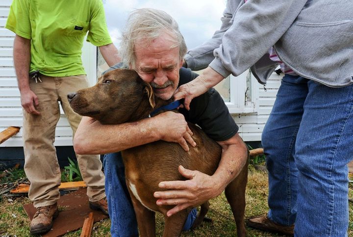 Greg Cook a retrouv&eacute; son chien Coco le 2 mars 2012 dans les d&eacute;combres de sa maison, d&eacute;vast&eacute;e par une tornade, dans l'Alabama (Etats-Unis). (GARY COSBY JR / AP / SIPA)