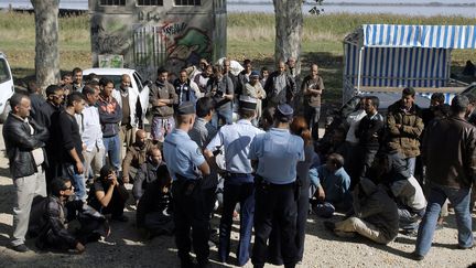 Les gendarmes discutent avec les travailleurs Sahraouis, le 5 octobre &agrave; Pauillac (Gironde). La veille, ces derniers s'&eacute;taient battus avec des travailleurs locaux d'origine marocaine, dans les rues du village.&nbsp; (NICOLAS TUCAT / AFP)