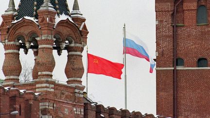 Une image prise le 18 décembre 1991 : elle montre les drapeaux soviétique (à gauche) et russe, flottant au-dessus du Kremlin, entre les tours de la Porte Spasskaïa à Moscou sur la Place Rouge. Les drapeaux soviétiques seront descendus pour la dernière fois le 31 décembre 1991 et remplacés par les drapeaux russes, marquant la fin de l'Union soviétique.&nbsp; (ALAIN-PIERRE HOVASSE / AFP)