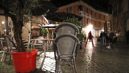 Des cafetiers rangent leur mobilier de terrasse dans le centre ville de Strasbourg le 24 octobre peu avant minuit l'heure de mise en application du couvre-feu. (JEAN-MARC LOOS / MAXPPP)