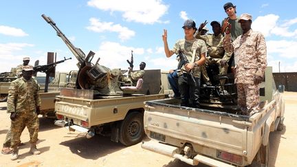 Des hommes du GNA entrent dans la ville d'Abu Qurain, à mi-chemin entre Tripoli la capitale et Benghazi, tenue par le maréchal Khalifa Haftar. (MAHMUD TURKIA / AFP)