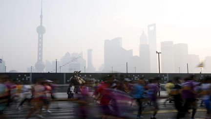 Les concurrents du marathon de Shanghai passent devant les gratte-ciels du quartier de Pudong, le 4 d&eacute;cembre 2011.&nbsp; (EUGENE HOSHIKO / AP / SIPA )