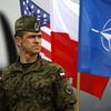 Un soldat polonais se tient devant des drapeaux am&eacute;ricains, polonais et de l'Otan, &agrave; Swidwin (Pologne),&nbsp;lors de l'arriv&eacute;e de 150 soldats am&eacute;ricains pour des exercices militaires en Pologne et dans les pays baltes, le 23 avril 2014. (KACPER PEMPEL / REUTERS)