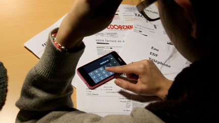 Une femme calcule le montant de ses factures. Photo d'illustration. (PIERRE HECKLER / MAXPPP)