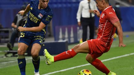 Le Lyonnais Maxence Caqueret face au Nîmois Andrés Cubas  (JEAN-PHILIPPE KSIAZEK / AFP)